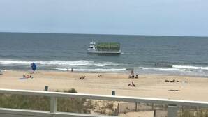 A beach with people relaxing and a boat with a birthday banner.