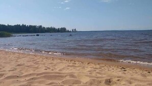Una playa arenosa con olas suaves lamiendo la orilla.