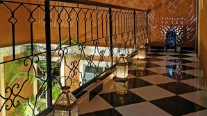A corridor with a checkered floor, ornate railing, and decorative lanterns. - Close to everything in the medina - Authentic renovated Moroccan house (Marrakech)