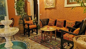 A traditional Moroccan interior with a fountain, patterned cushions, and a tiled floor. - Close to everything in the medina - Authentic renovated Moroccan house (Marrakech)