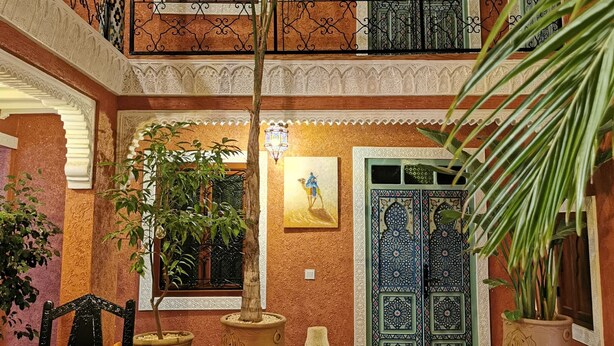 A spacious courtyard with a fountain, potted plants, and a chair. - Close to everything in the medina - Authentic renovated Moroccan house (Marrakech)