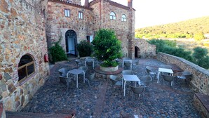 Un bâtiment en pierre doté d’une cour intérieure aménagée avec des espaces de repos en plein air.