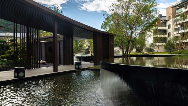 A modern building with a water feature in front. - Ramada by Wyndham Guilin Yangshuo Resort (Guilin)