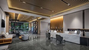 A modern lobby with a reception desk, seating area, and a view of the outdoors. - Ramada by Wyndham Guilin Yangshuo Resort (Guilin)