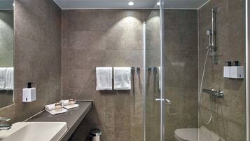 Un bagno moderno con doccia vetrata, lavabo e portasci.