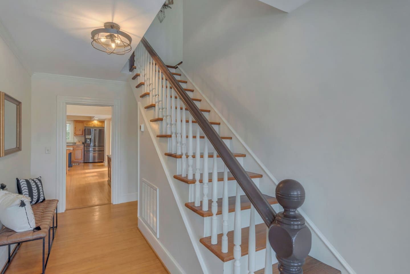 A staircase with wooden steps and white balusters, leading to an upper floor.
