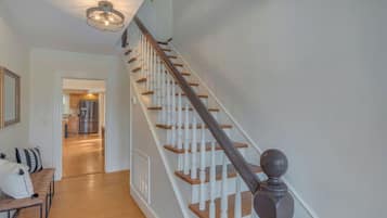 A staircase with wooden steps and white balusters, leading to an upper floor.