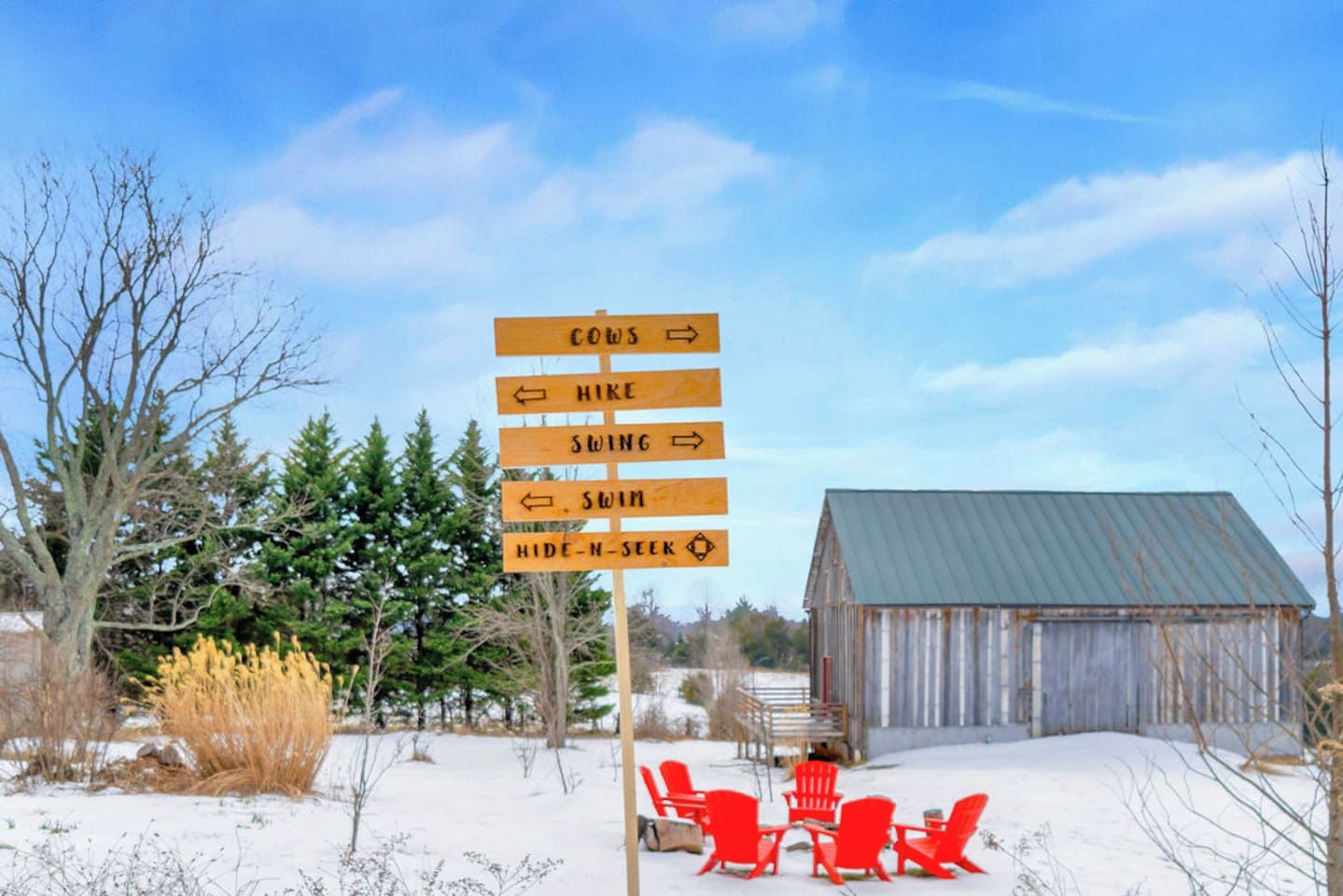 A wooden signpost with directions for activities such as hiking, swinging, swimming, and hide-and-seek.