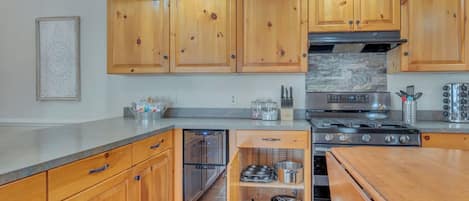 A modern kitchen with wooden cabinets, stainless steel appliances, and a built-in oven.
