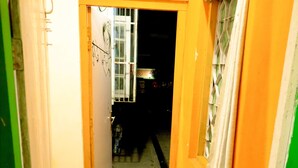 Un escalier étroit menant à une pièce dotée d’une fenêtre et d’une porte.