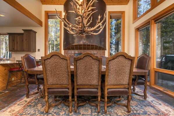 Comedor con una gran mesa de madera y cuatro sillas tapizadas.