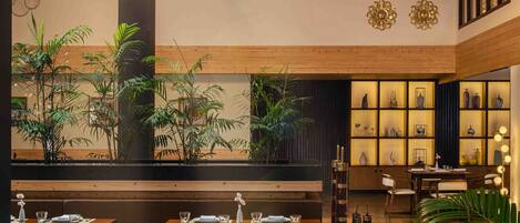 Un restaurante con techo y paredes de madera, mesas dispuestas para comer y estantes decorativos.