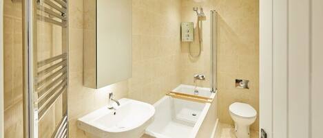 A modern bathroom with a sink, bathtub, and toilet.