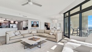 Ein modernes Wohnzimmer mit einem Ecksofa, einem Couchtisch und Meerblick durch große Fenster.