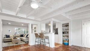 A spacious living area with a sofa set, a coffee table, and a bar area with stools.