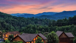 A residential area with houses, a clear sky, and a mountainous backdrop.
