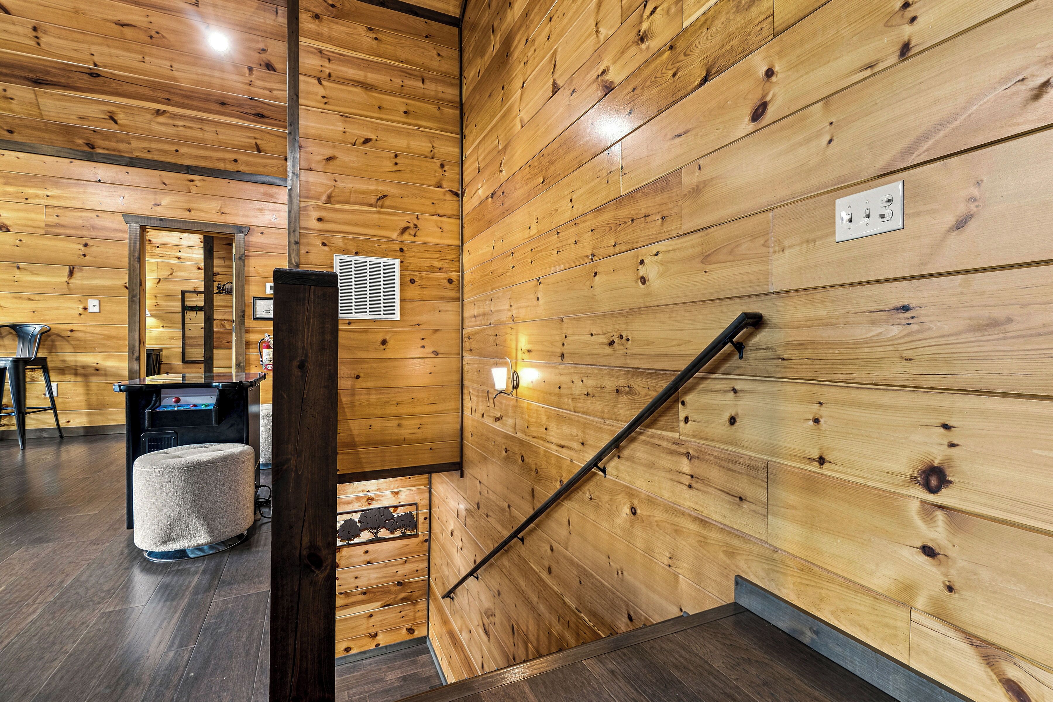 A wooden interior with a staircase, a bar area, and a seating space.
