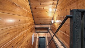 A wooden interior with a staircase leading to a door.