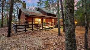 A log cabin with a deck, surrounded by trees. - The Busy Beaver Lodge (McCurtain County)