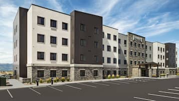 A multi-story hotel with a modern design, featuring a stone facade and a covered entrance.