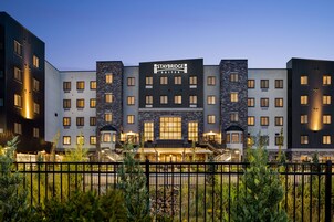 Un hotel Staybridge Suites de diseño moderno, con varios pisos y una entrada destacada que incluye una escalera.