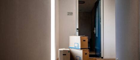 A hallway with a door marked 259, leading to a room. There are three cardboard boxes stacked in the hallway.