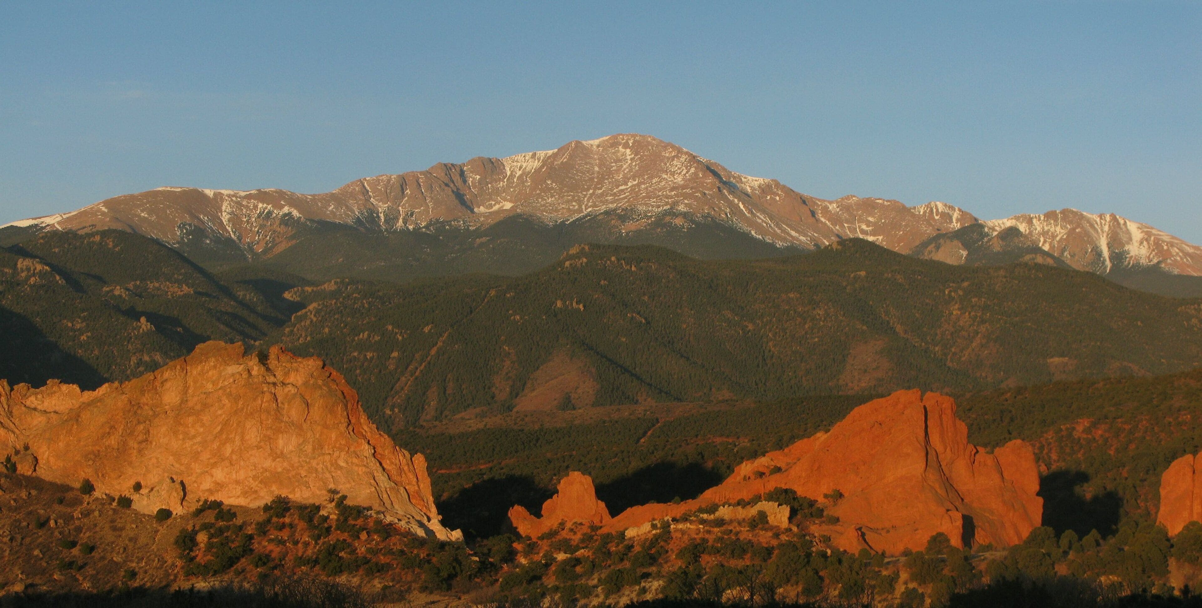 A mountain range with prominent rock formations and a clear sky.