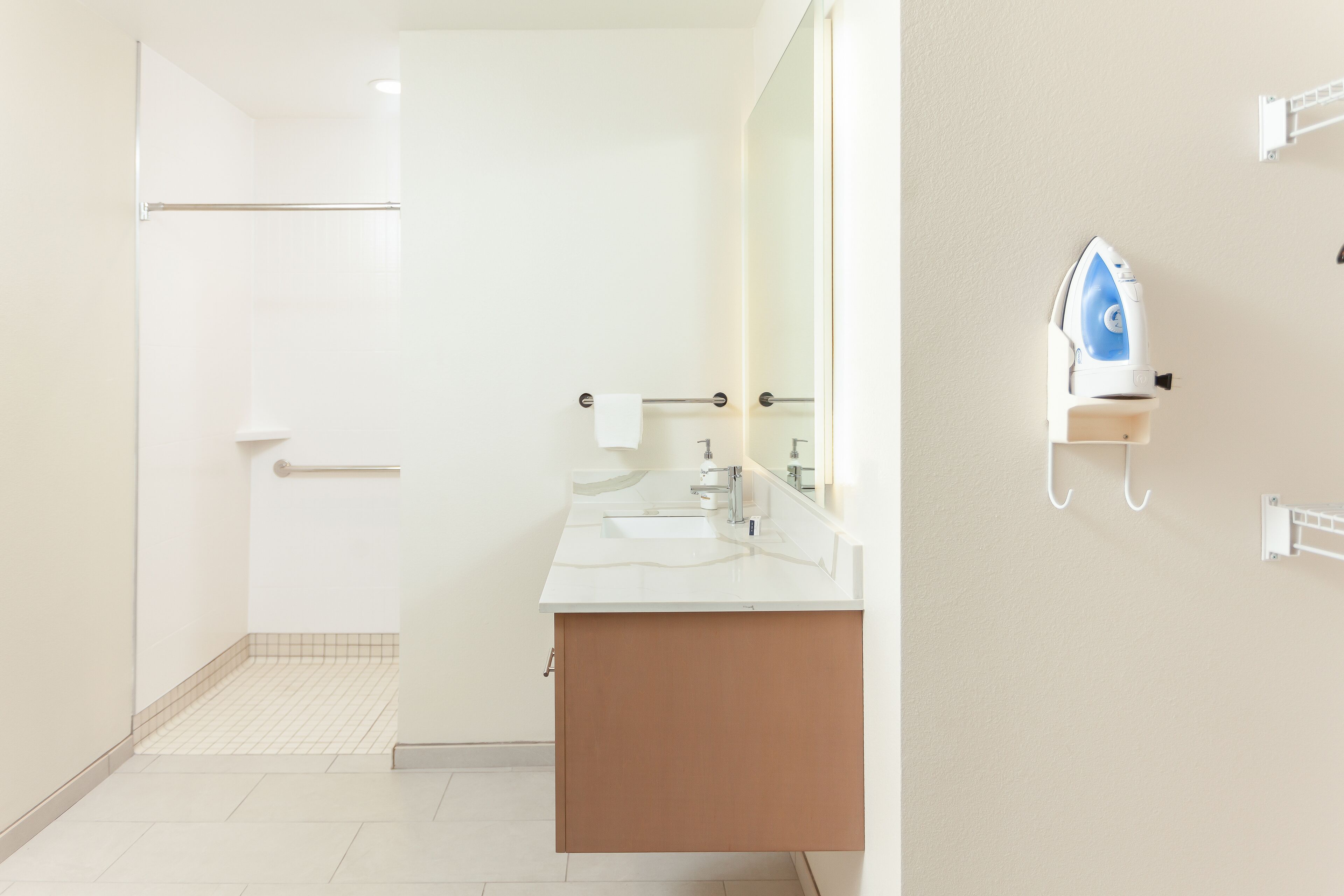 A modern bathroom with a shower, a sink, and a mirror.