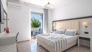 Une chambre d’hôtel moderne dotée d’un grand lit, d’un bureau et d’un balcon offrant une vue sur la verdure.