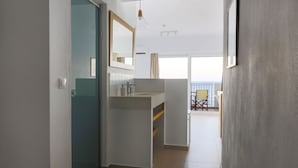 A modern bathroom with a glass shower enclosure, a white sink, and a mirror. - Sea Breeze Hotel (Hersonissos)