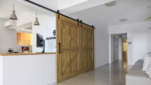 A reception area with a wooden sliding door, a reception desk, and a sofa in a modern interior. - Sea Breeze Hotel (Hersonissos)