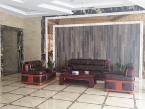 Un hall con un conjunto de sofás, una mesa de centro y una puerta.