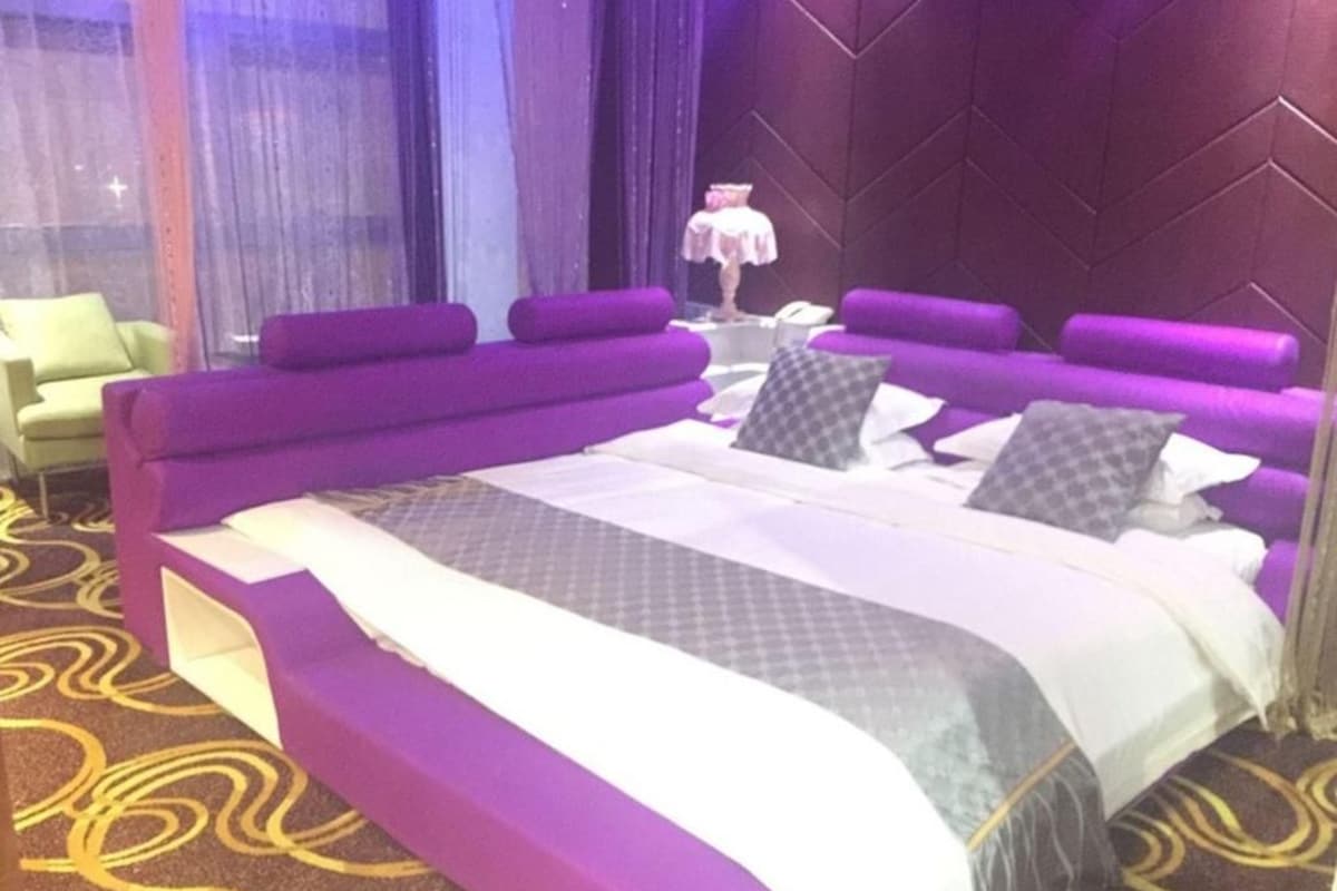 Une chambre d’hôtel avec un grand lit, un canapé et un fauteuil.