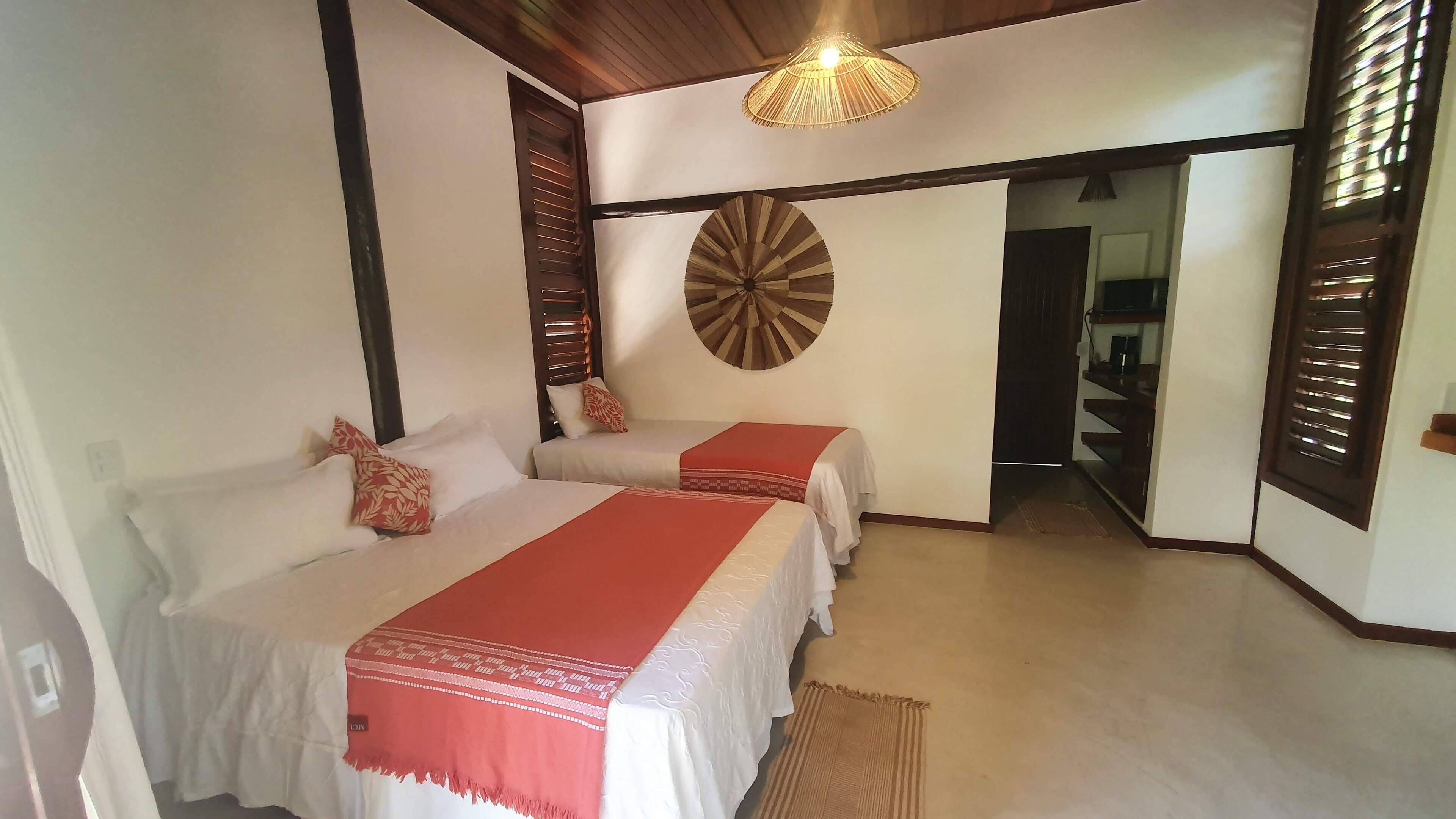 Una habitación con dos camas, un reloj de pared grande y una lámpara colgante.