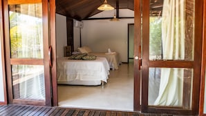 A room with a bed, a nightstand, and a hanging light fixture. - Vivant Eco Beach OFICIAL (Maraú)