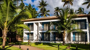 A two-story building with balconies, surrounded by palm trees and a clear sky. - Vivant Eco Beach OFICIAL (Maraú)