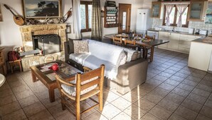 Una sala de estar acogedora con chimenea, comedor y cocina.