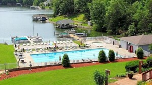 Une piscine avec des chaises longues et une zone aménagée en quai.
