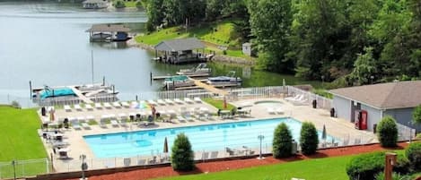 A swimming pool with lounge chairs and a dock area.
