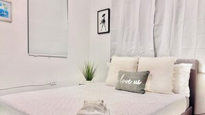A neatly made bed with a folded towel, a small potted plant, and a pillow with "I love us" text. - Near airport / Isla Verde / Dinning & top attractions (Carolina)