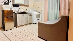 A compact kitchen with a refrigerator, stove, microwave, and sink. - Near airport / Isla Verde / Dinning & top attractions (Carolina)