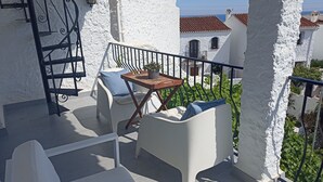 A balcony with white walls, a wooden table, and two white chairs. - Refurbished Villa With Private Garden And Large Terraces (Nerja)