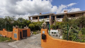 A residential building with a stone facade, a number '35' sign, and a patio area with outdoor furniture.