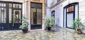 Un edificio con un cartel que dice 'BUREAUX' y una entrada cerrada. Hay plantas en macetas frente a las puertas.