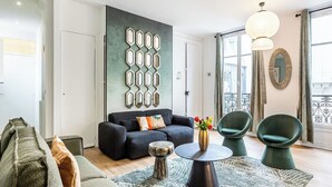 A modern living room with a sofa, chairs, a coffee table, and a decorative wall.