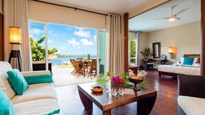 A spacious living area with a sofa, coffee table, and a view of the ocean. - EAST KEYS Suite 127 Prestige: private pool, sea view, beach (Le François)