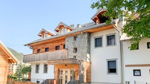 A multi-story building with a stone facade, wooden balconies, and a staircase leading to the entrance. - Old Village House - Catherine's place (Bohinjska Bistrica)