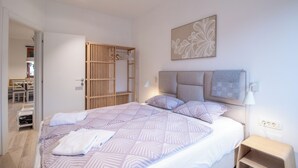 A neatly arranged bedroom with a bed, bedside table, and a wooden wardrobe. - Old Village House - Catherine's place (Bohinjska Bistrica)