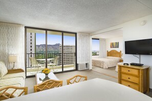 Enjoy breathtaking mountain views from the balcony, featuring a comfortable bed, TV, and desk.