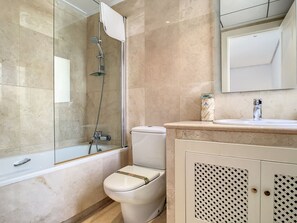 Bathtub, hair dryer, towels, toilet paper